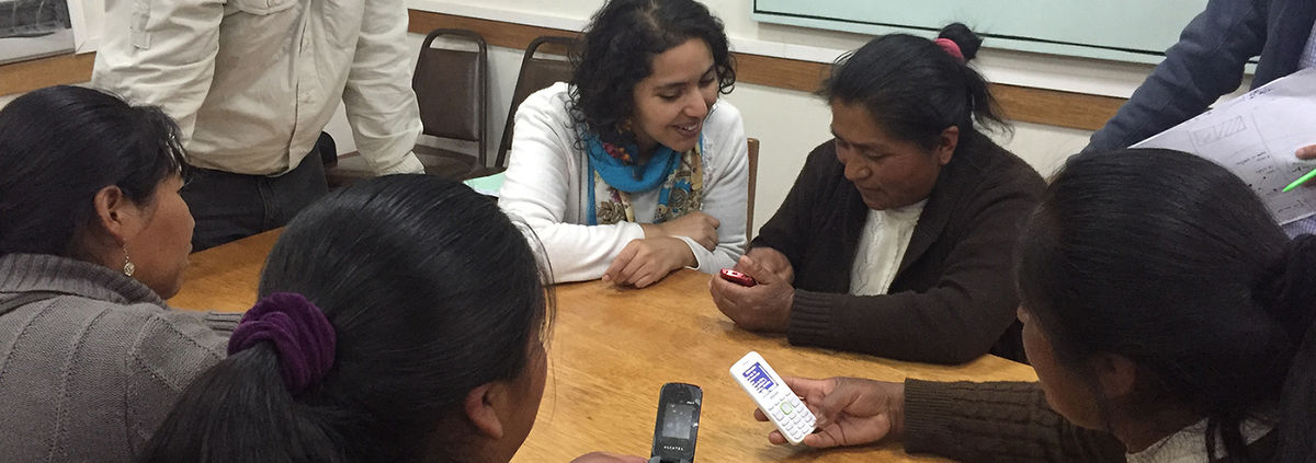photos from Peru ASBANC pilot-women-around-table-holding-phone