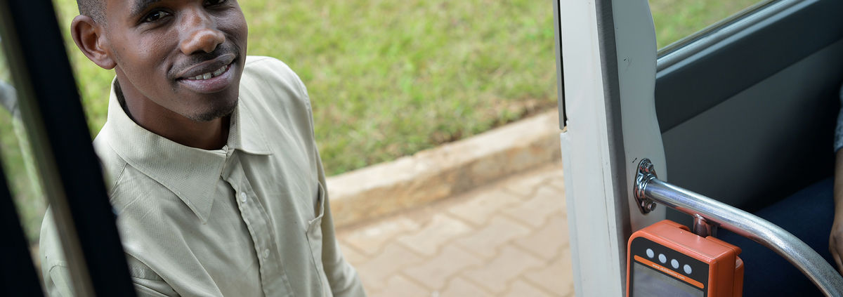 man smiling using digital bus card system in Rwanda – 2