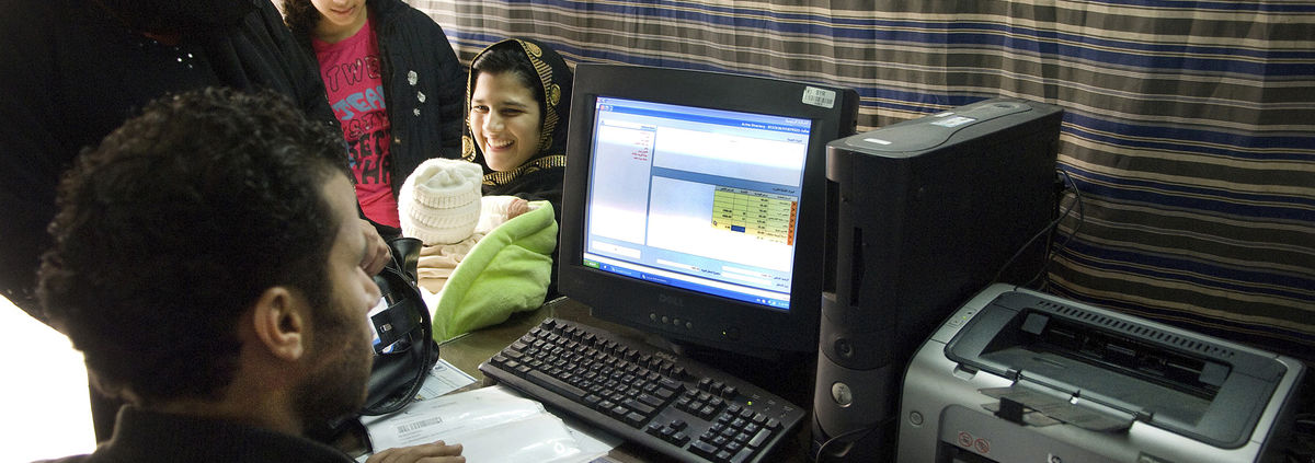 family smiling looking at computer with man